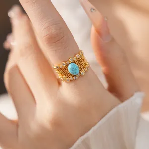 Detail of vintage gold-plated ring with turquoise stone and cubic zirconia lace design