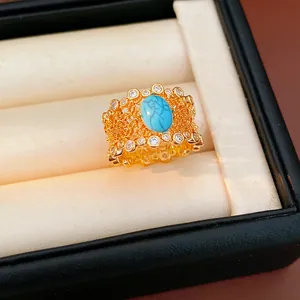 Detailed view of a vintage gold-plated filigree ring with oval turquoise and zircon