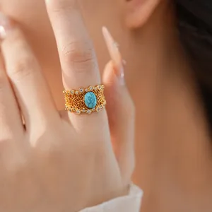 Close-up of vintage gold-plated ring with floral hollow design and blue turquoise center