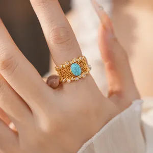 Detailed shot of a vintage gold-plated hollow lace ring featuring a turquoise stone