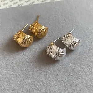 Detailed view of textured flower stud earrings with 18k gold plating and zircons