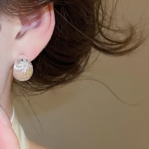 Close-up of elegant 18k gold plated zircon star flower stud earrings on model