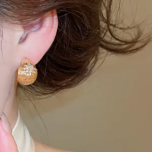 Close-up of 18k gold plated flower stud earring with zircon on model's ear