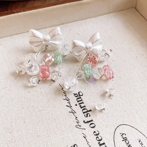 Gros plan de boucles d'oreilles nœud style princesse avec glands en cristal coloré