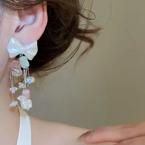 Boucles d'oreilles nœud avec des glands en cristal coloré et des perles élégantes