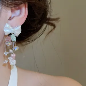Gros plan détaillé de boucles d'oreilles nœud élégantes avec pompons en cristal