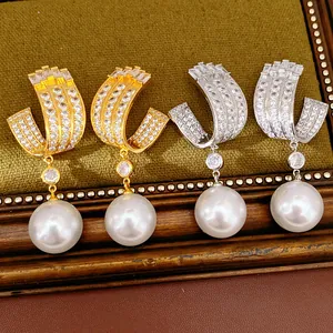 Detailed view of U-shaped silver needle earrings with cubic zirconia and pearls