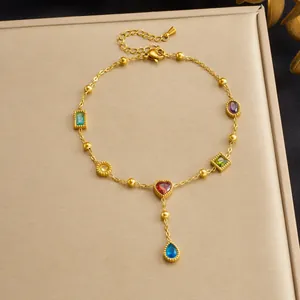 Dettaglio di una cavigliera in acciaio inossidabile dorato con zirconi colorati a cuore.
