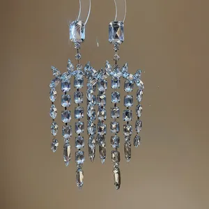 Dettaglio di orecchini ad ago in argento con nappe di cristallo quadrato molto scintillante