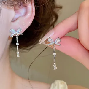 Detailansicht eleganter Zirkon-Schleifenohrringe mit Quaste und Perlen-Akzent