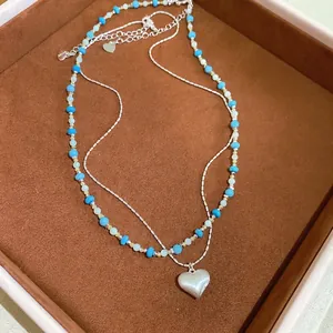 Detail view of French vintage turquoise beaded necklace with silver heart pendant
