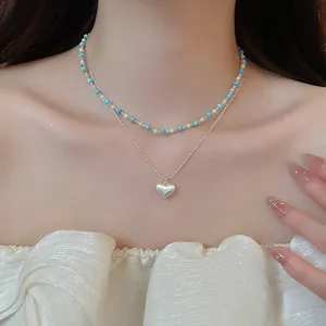 Detail of layered French vintage necklace with turquoise beads and heart pendant