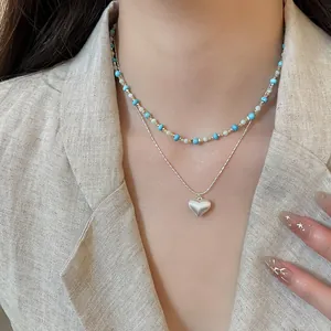 Detailed view of dainty double-layered necklace featuring turquoise beads and silver heart