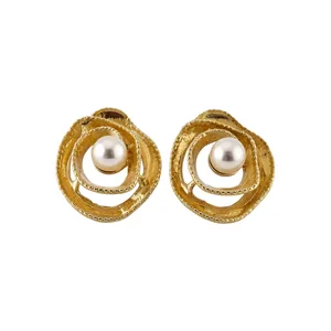 Orecchini a perno dorati a cerchio intrecciato con perla bianca, stile minimalista.