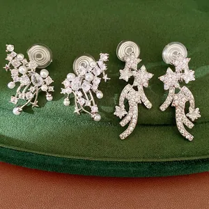 Detailed close-up showing silver-toned star and pearl ear clips with sparkling zircons