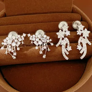 Close-up of elegant zircon and pearl clip-on earrings displayed in a velvet jewelry box