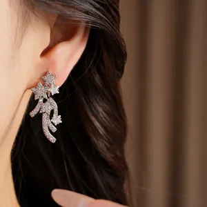 Close-up view of sparkling star-shaped stud earrings with cubic zirconia on model ear