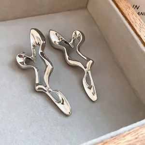 Detailed view of silver irregular hollow-out stud earrings in a jewelry box