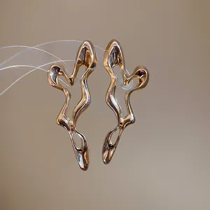Detailed close-up of gold irregular hollow earrings with a unique abstract design.