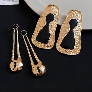 Vintage geometric irregular metal earrings with gold hammered texture and black accents.