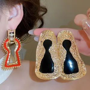 Vintage gold geometric metal earrings with artistic red and black enamel details