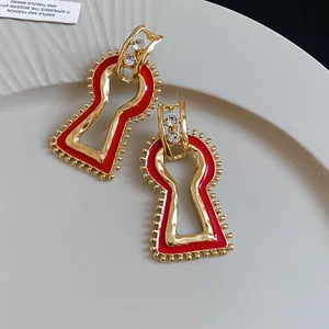 Close-up of vintage geometric red enamel earrings with gold-plated finish