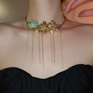 Exaggerated gold metal choker necklace with floral, conch shell and long chain tassels.