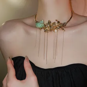 Macro view of a gold conch flower choker necklace featuring long elegant tassels