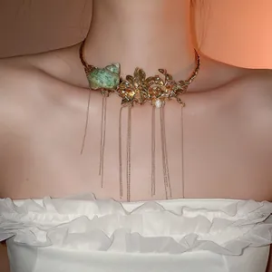 Detailed close-up of a vintage gold flower and seashell tassel choker necklace.