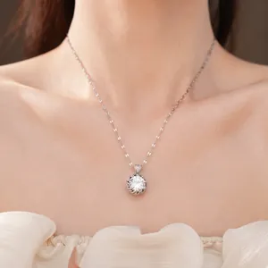 Élégant collier argenté avec pendentif rond en zircon porté sur le cou d'un modèle.