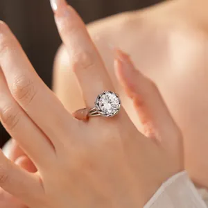 Gros plan d'une élégante bague en zircone ronde avec halo décoratif sur la main d'un modèle.