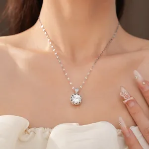 Détail en gros plan d'un collier en argent avec un pendentif rond en zircon étincelant.