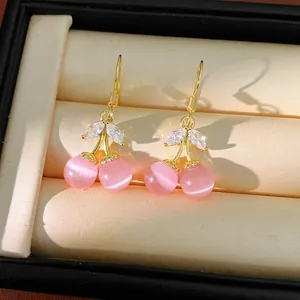 Close-up view of elegant pink cherry drop earrings with cat's eye stones and zirconia