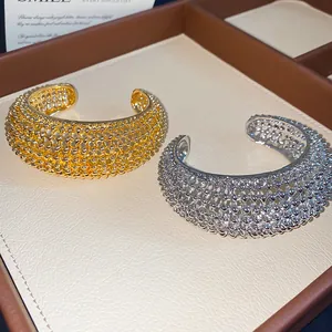Detailansicht von offenen Metallarmreifen mit hohler Schmelzperlenstruktur in Gold und Silber