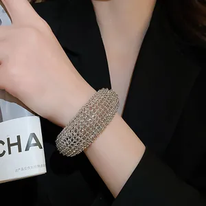Nahaufnahme eines silbernen, hohl gearbeiteten Armreifs mit schmelzenden Perlen für Damen