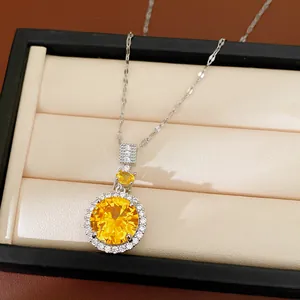 Dettaglio di una collana d'argento con un grande ciondolo in zircone giallo rotondo.