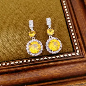 Squisiti orecchini pendenti argentati con brillanti zirconi gialli rotondi e accenti