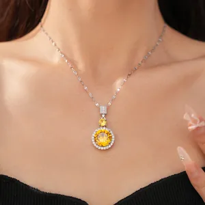 Primo piano di collana d'argento con pendente halo in zirconia gialla sul collo