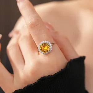 Dettaglio ravvicinato di un elegante anello in zircone giallo tondo con montatura halo