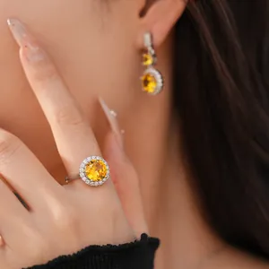 Primo piano di un elegante set coordinato di anello e orecchini con zircone giallo