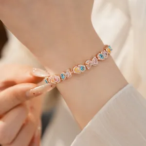 Close-up of an 18k gold plated bracelet with colorful heart zircons on a woman's wrist