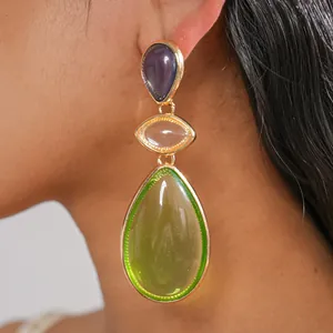 Macro view of three-tiered vintage resin water-drop earrings with gold metal frame