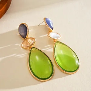 Detailed macro view of vibrant lime green and lavender resin teardrop drop earrings