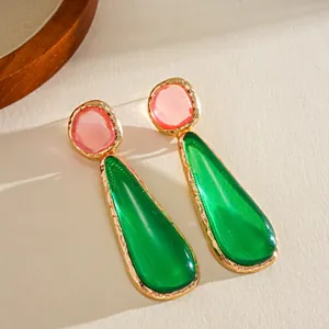Macro detail of vintage resin teardrop earrings with pink round top and green drop