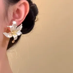Elegant French 3D iris flower metal earrings with pearlescent finish worn on ear