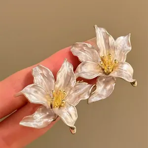 Close-up of French iris metal earrings with elegant pearlescent finish and gold stamen