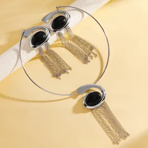 Close-up detail of silver choker and earring set with black stones and long chain tassels