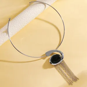 Detailed macro view of silver snail pendant choker with black stone and long metal tassels