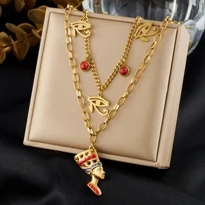 Detail of gold-plated layered necklace featuring Eye of Horus and Nefertiti pendant.