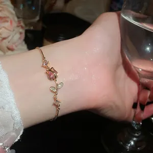Elegante bracciale in oro rosa con zirconi rosa scintillanti e un ciondolo a fiore